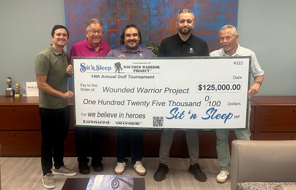 Five men holding a large check for $125,000 from Sit 'n Sleep at an event.